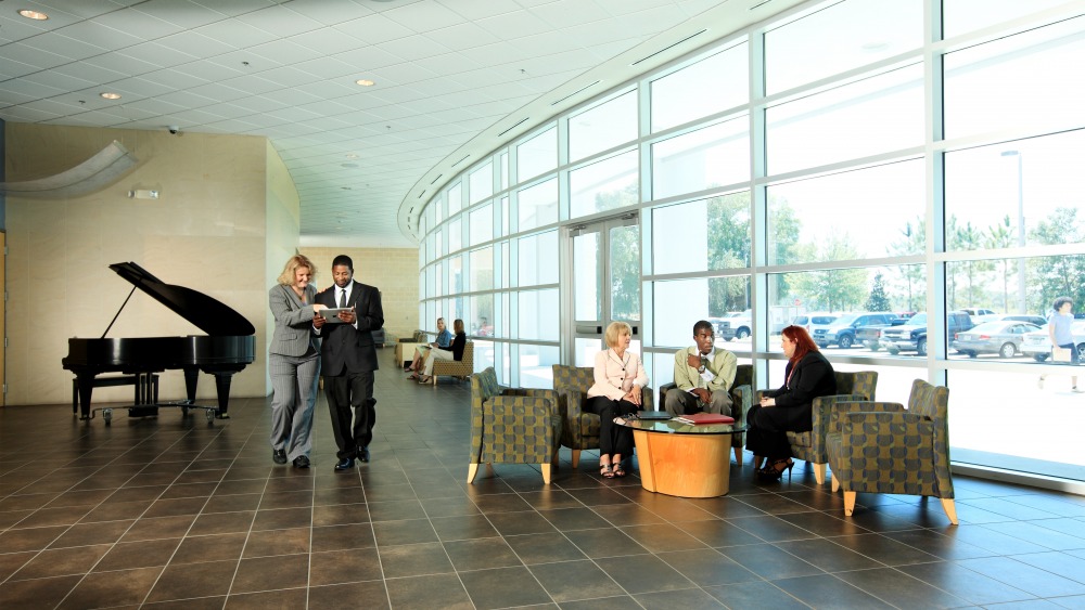 People dressed professionally speaking inside the lobby of the Trinkle Center