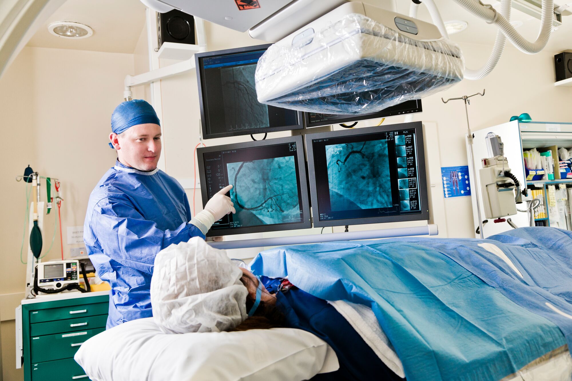 Person in blue scrubs standing over patient