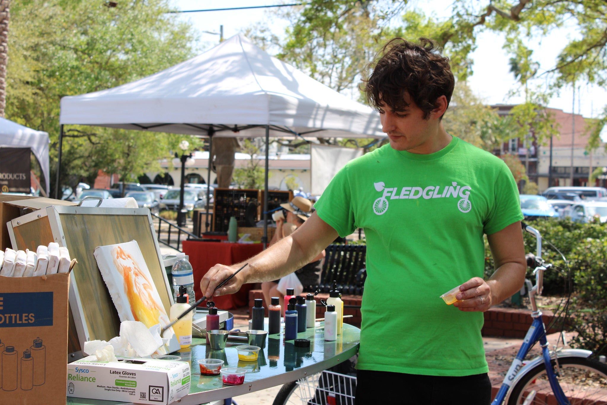 Person in green t-shirt holding paintbrush