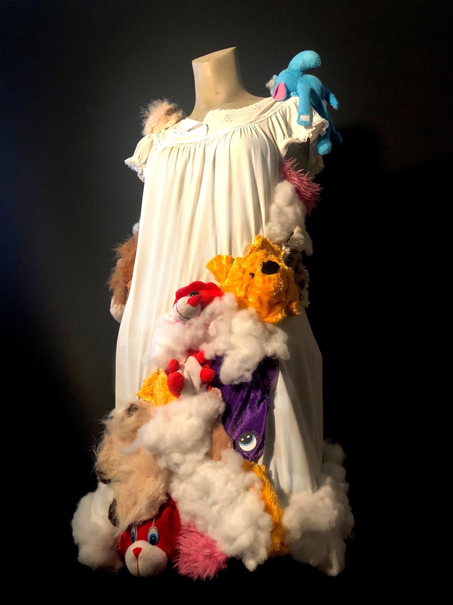 Student art exhibition showing a dress and stuffed animals