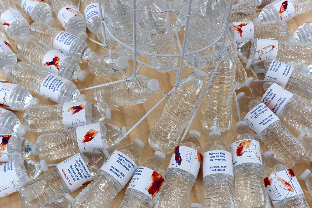 Water bottles with weather map labels scattered around a metal stand.
