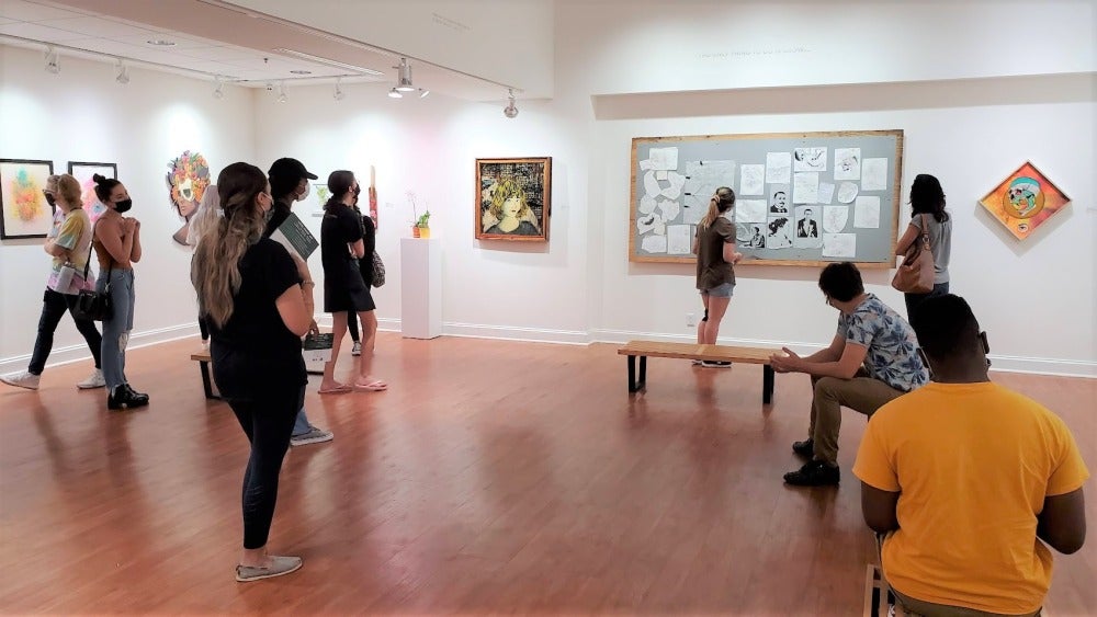 Scattered individuals looking at work in an art gallery