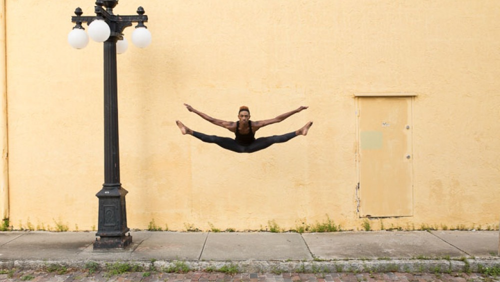 Dance performer jumping next to lamp post