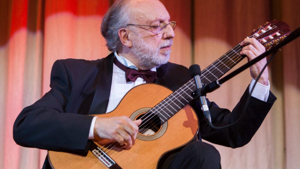 Photo of Jose Luis Merlin holding guitar