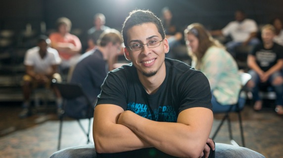 smiling male theatre student sitting in a chair