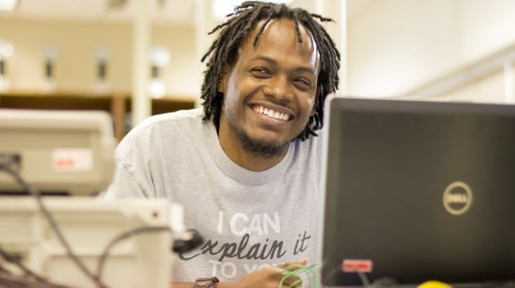 African American male sitting at desk with laptop in front of him