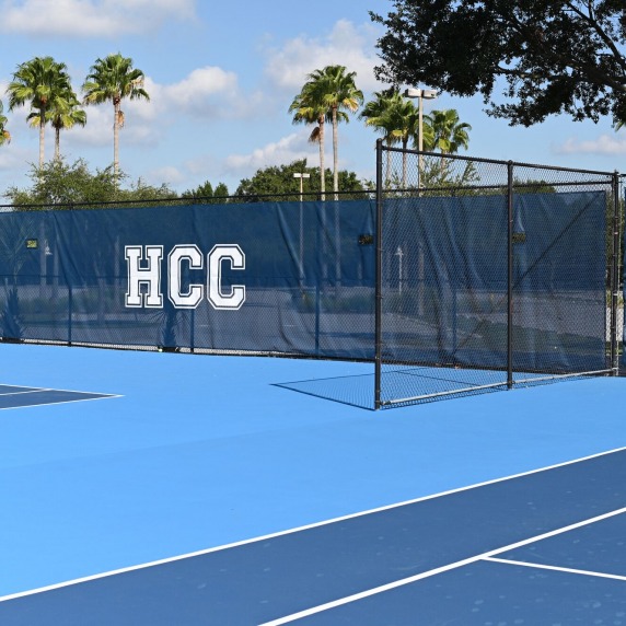 Tennis court with HCC Hawks banners in background