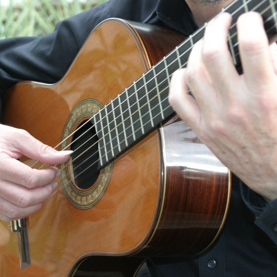 Close up photograph of Professor Mark Switzer playing guitar