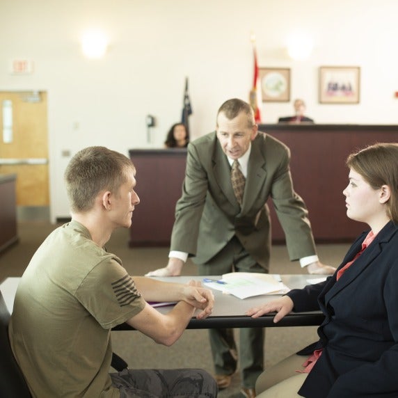 two criminology students sitting in a courtroom while a mock trial is in session
