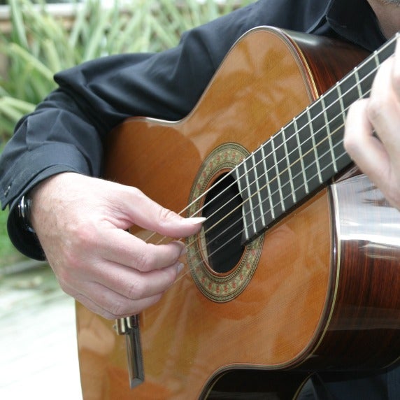 Close up photograph of Professor Mark Switzer playing guitar