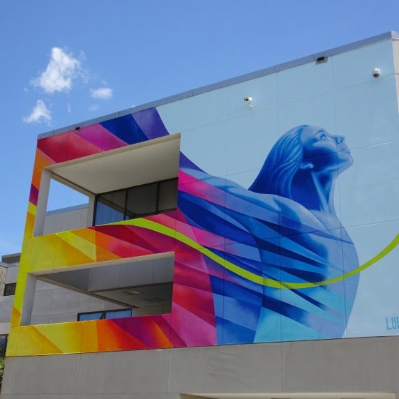 Colorful mural of a woman with arms lifted