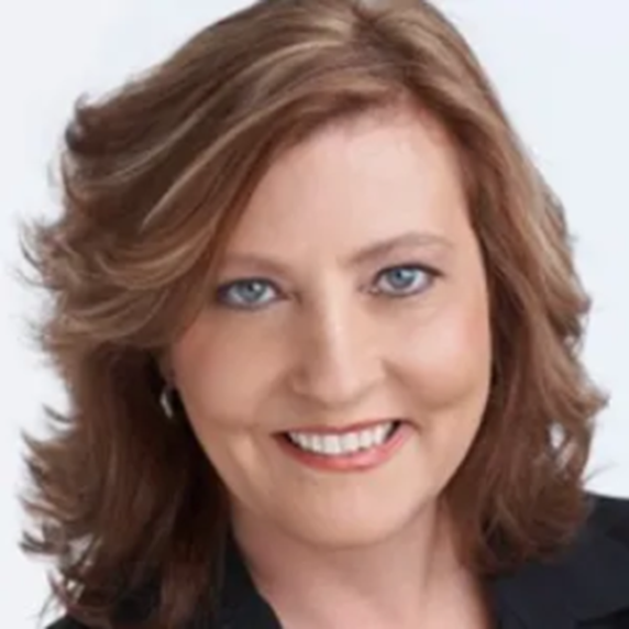 Brown haired woman smiles at camera. 