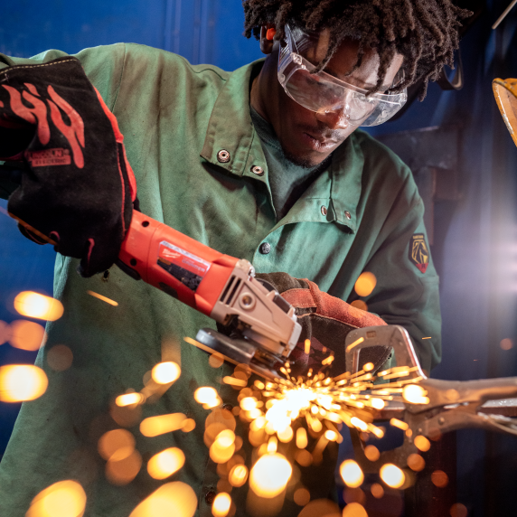 Black male welding student working with a machine. 