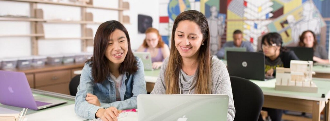 Two students looking at laptop together