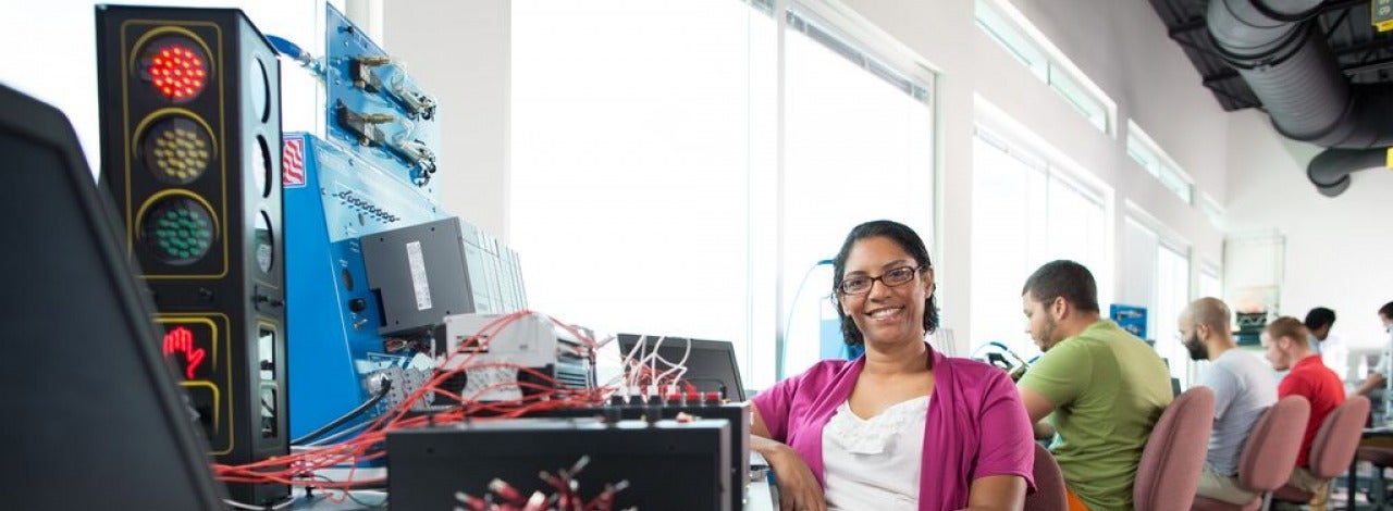 Student sitting at a desk smiling. 