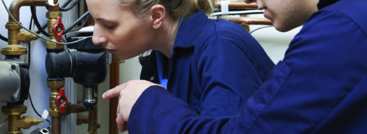 Two people working on plumbing