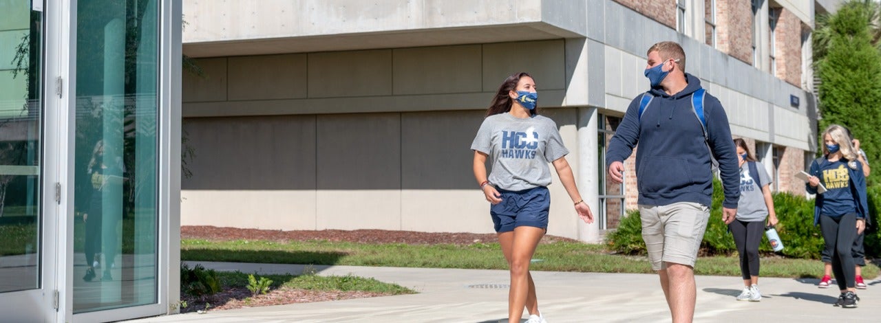HCC students walking outside wearing face masks