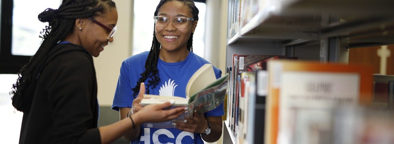 Student showing book to another student