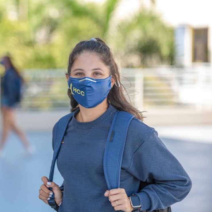 Masked woman wearing backpack