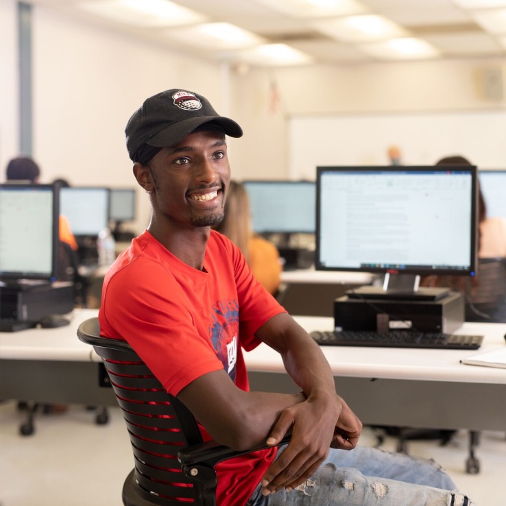 Male student sitting in front of a computer. 