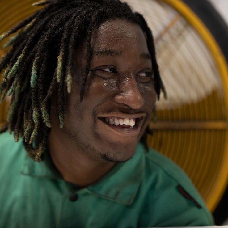 Smiling man in front of large fan