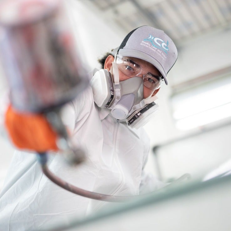 Workforce student painting a car.