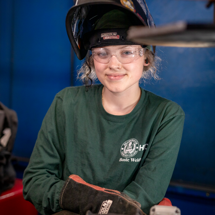 Female welding student smiling at the camera.